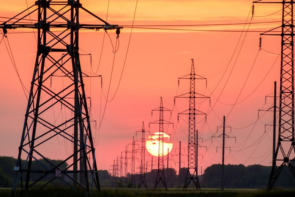 Norgespris – tańszy prąd po rozpadzie rządu? Słupy elektryczne o zachodzi słońca