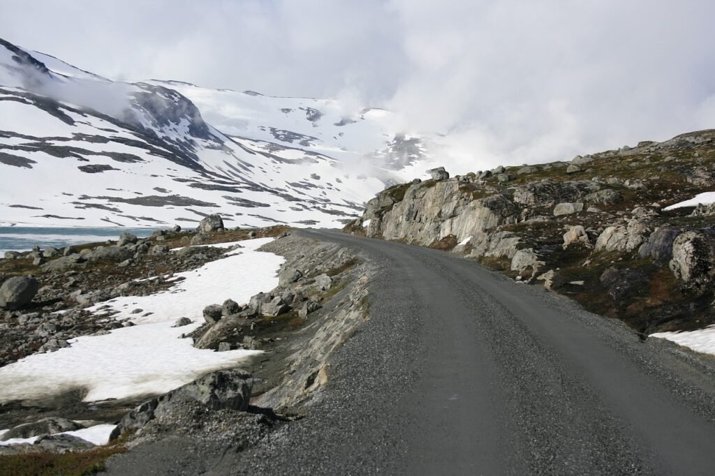 Egzotyczna Norwegia. Odwiedziny Droga przy skałach, ośnieżone góry. Surowy krajobraz, Norwegia zimą.