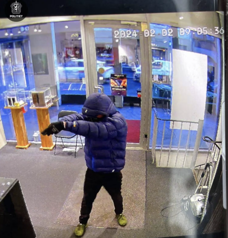 Mężczyzna w puchowej kurtce z pistoletem w ręku napada na sklep zegarmistrzowski. Foto: Polititet
