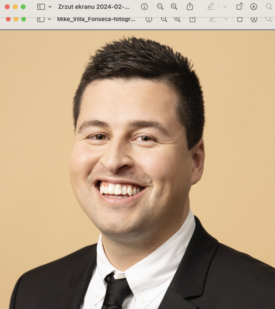 Uśmiechnięty duński polityk Mike Villa Fonseca (29 l.) w garniturze, na żółtym tle. Zdjęcie portretowe.