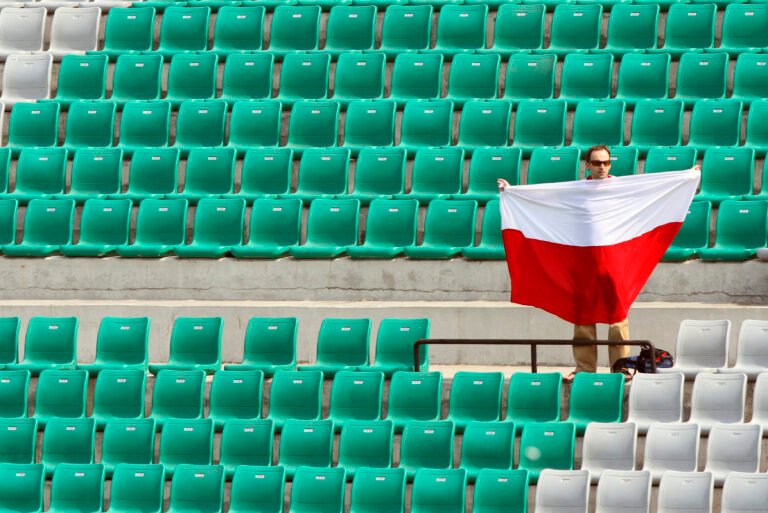 Kibic trzyma polską flagę narodową, gdy Polska gra z Singapurem w meczu kwalifikacyjnym mężczyzn do Igrzysk Olimpijskich w Londynie w 2012 r. Kibic trzyma polską flagę narodową, gdy Polska gra z Singapurem w meczu kwalifikacyjnym mężczyzn do Igrzysk Olimpijskich w Londynie w 2012 r. w New Delhi, 22 lutego 2012 r.