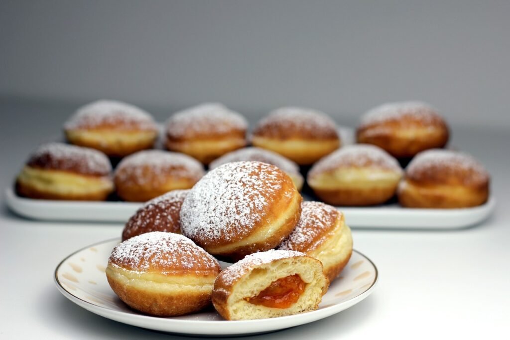 Pączki na tłusty czwartek Pączki posypane cukrem - pudrem na talerzach