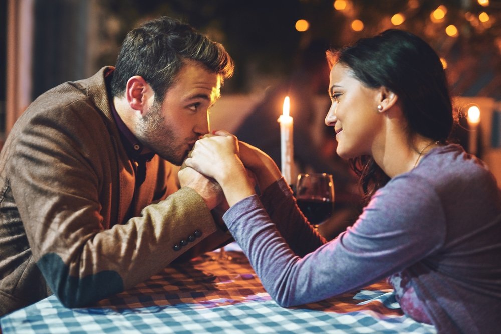 para trzymająca się za ręce podczas romantycznej kolacji