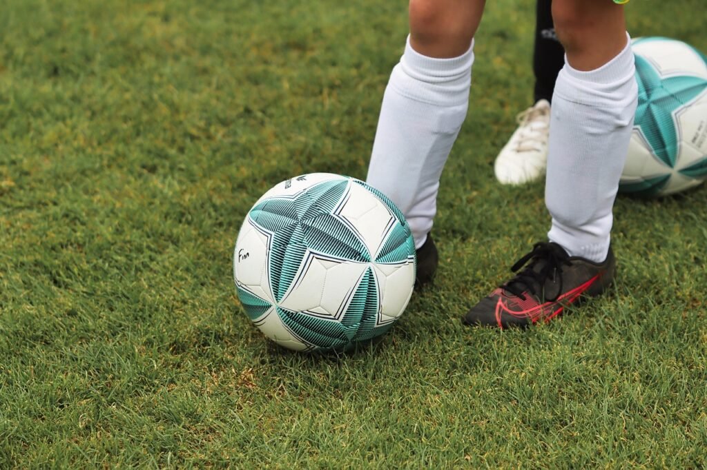 Lyngdal: Działacz sportowy skazany na 15 lat za nadużycia wobec dzieci Piłka, murawa, nogi młodego piłkarza w korkach, obuwie piłkarskie