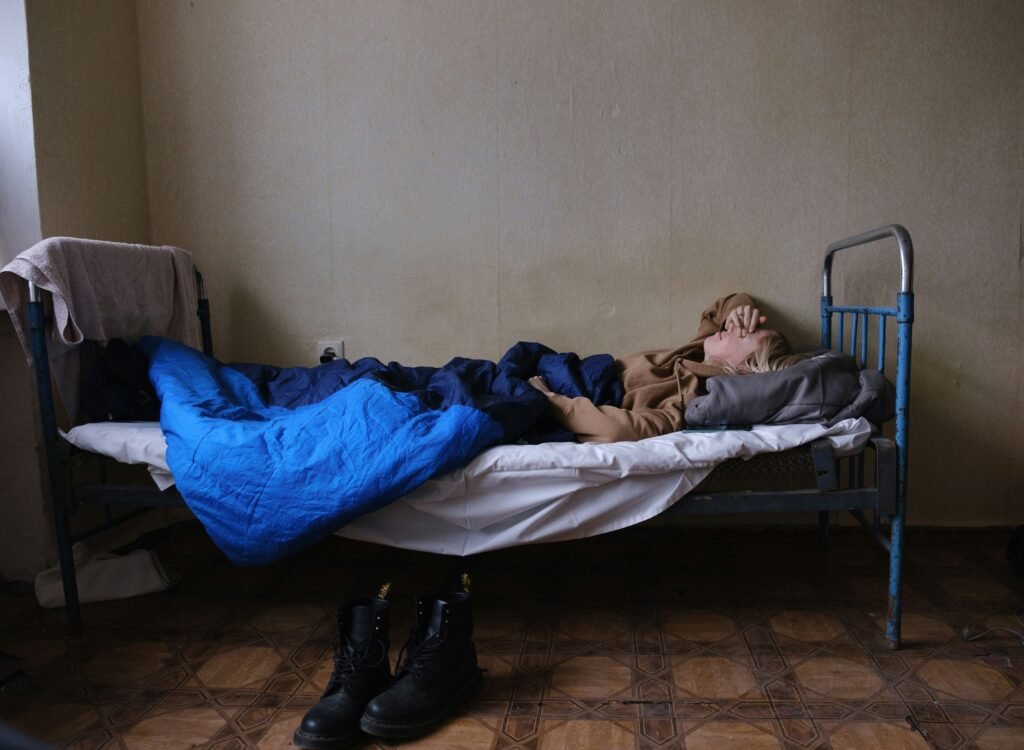 Norwegia zwiększa pomoc dla uprowadzonych ukraińskich dzieci i jeńców wojennych ukrainka leżąca na łóżku w schronisku